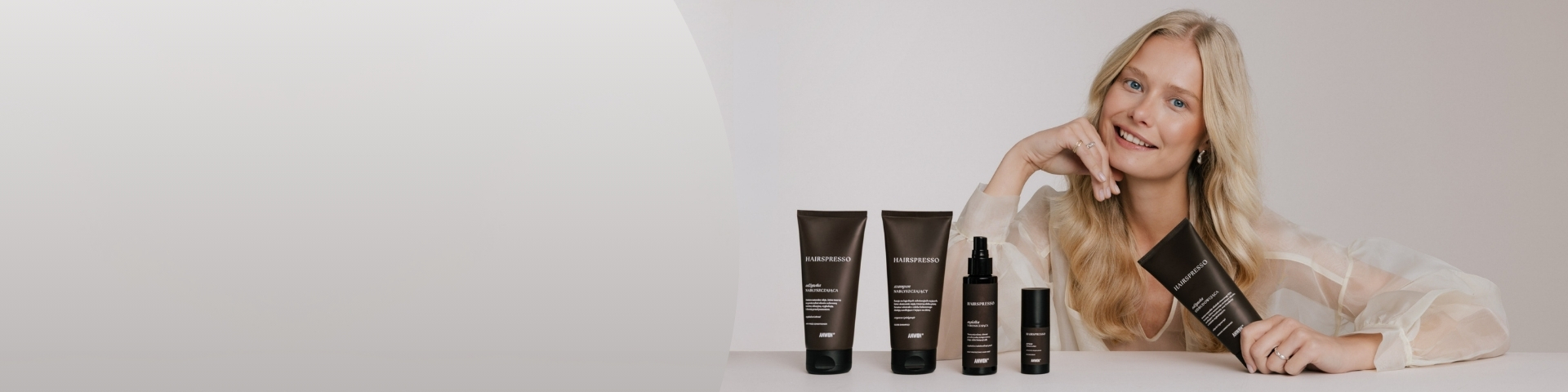 Anwen Hairspresso – linia kosmetyków do pielęgnacji włosów. Na banerze widoczne są szampon, odżywka oraz kosmetyki uzupełniające Hairspresso prezentowane obok osoby trzymającej produkt. Poznaj nowość.
